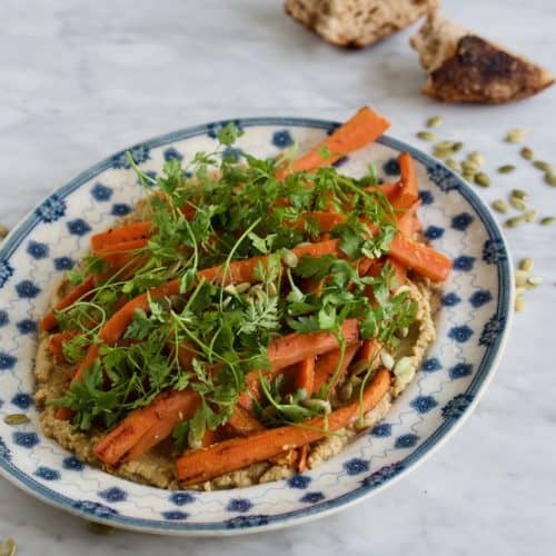 Hummus med bagte gulerødder, græskarkerner og krydderurter