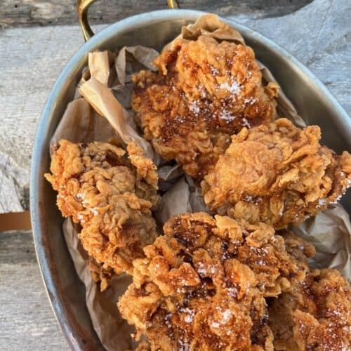 Sprø fried chicken med krydret sauce og salt på toppen.