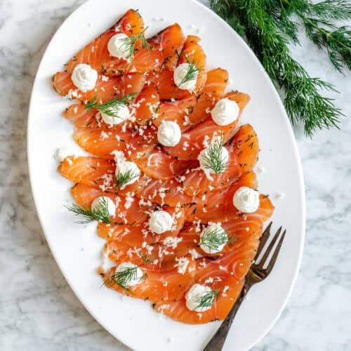 Gravad laks i tynde skiver anrettet med dild og creme – klassisk hjemmelavet gravad laks opskrift