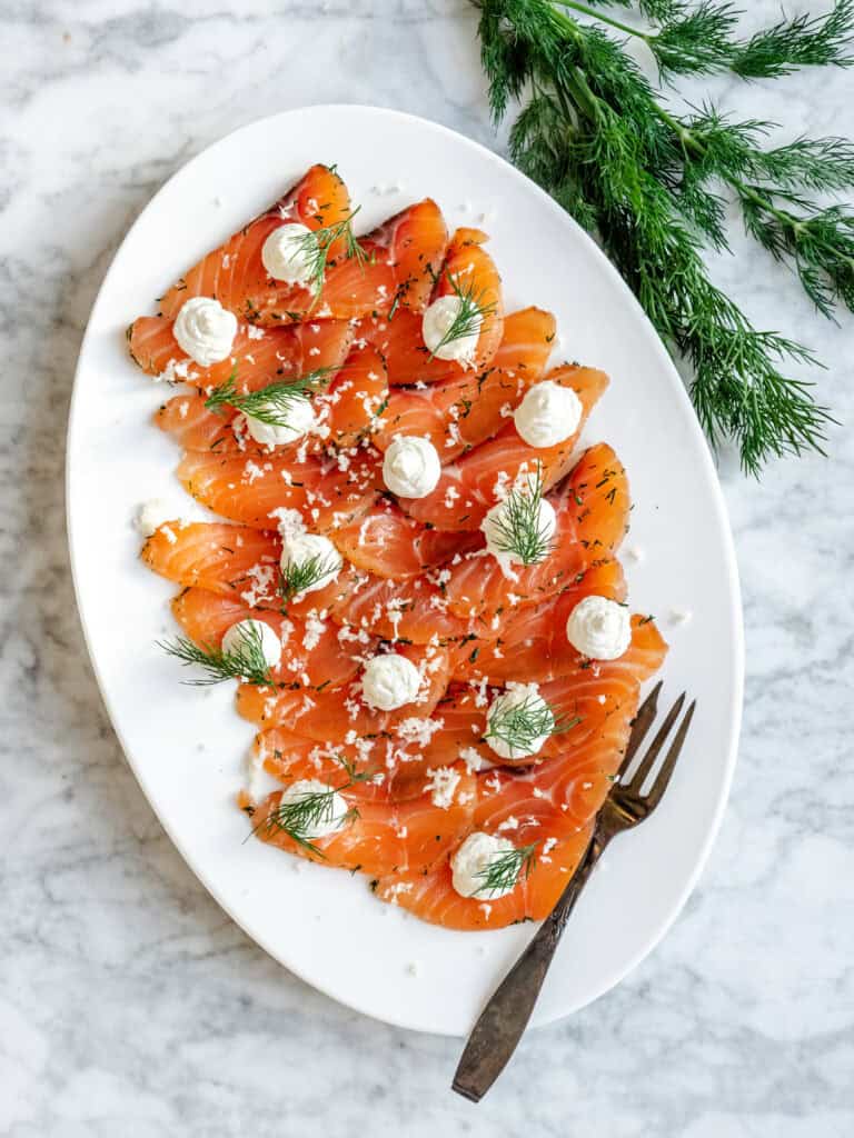 Gravad laks i tynde skiver anrettet med dild og creme – klassisk hjemmelavet gravad laks opskrift
