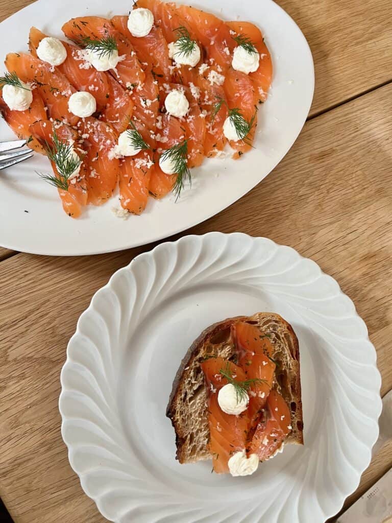 Gravad laks serveret på surdejsbrød med creme og dild – klassisk tilbehør til gravad laks