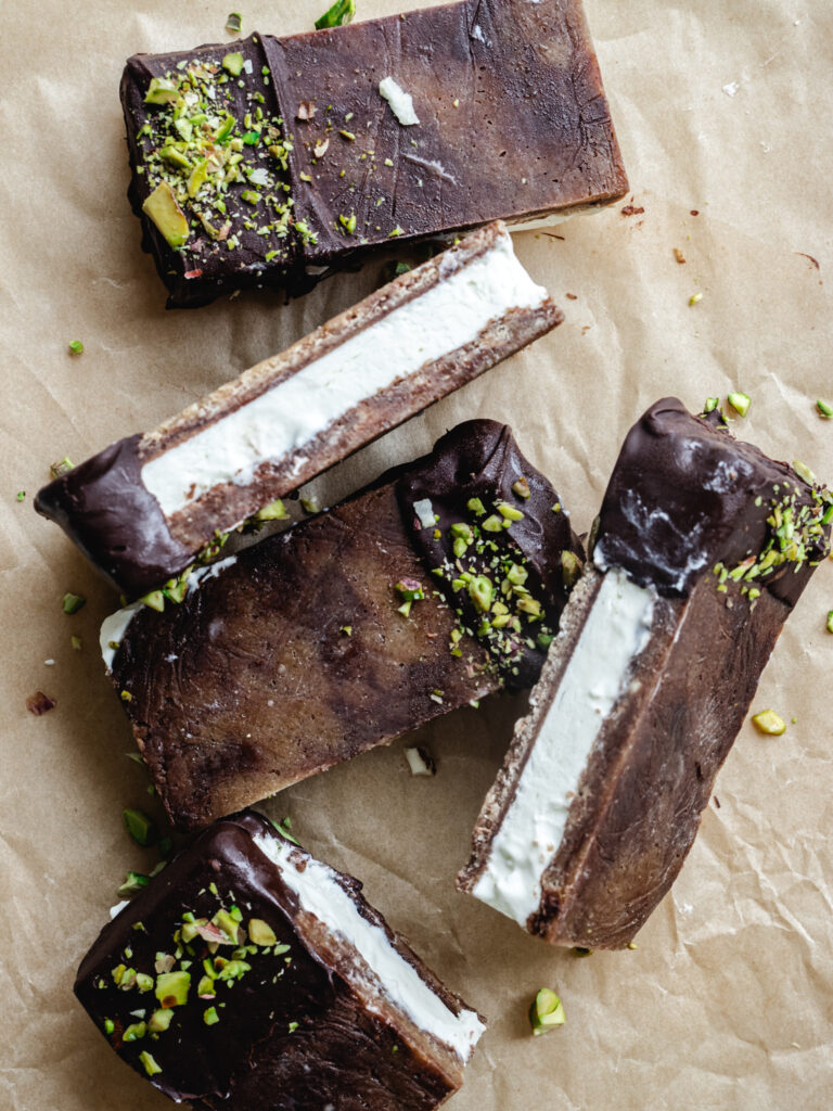 Cookie dough is-sandwiches med cremet vaniljeis, mørkt chokoladeovertræk, flagesalt og hakkede pistacienødder