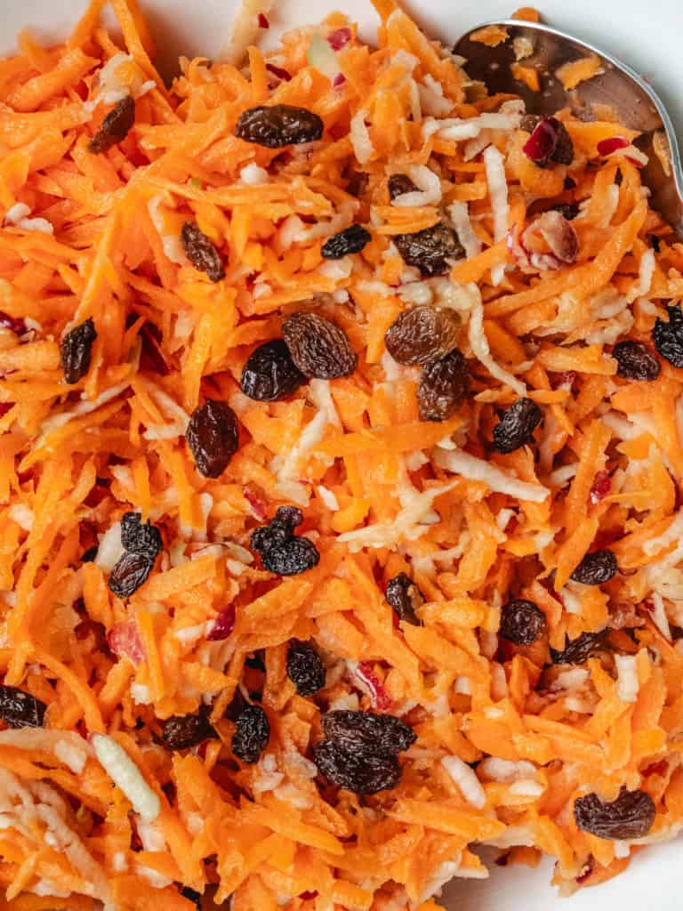 Frisk råkostsalat med gulerødder, rosiner og revet kokosnød.